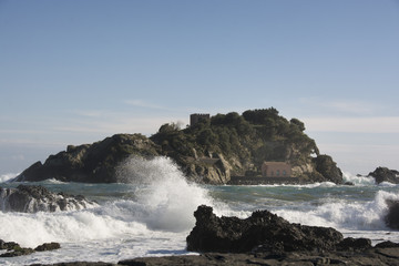 Fototapeta na wymiar waves crashing on the rocks at Acitrezza in Sicily