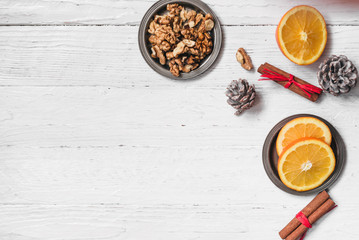 Orange in the cut, cinnamon, walnut on a white background. Branches of Christmas trees, gifts and bumps. A flat place, a place to copy, a top view. Holidays.