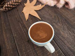 A cup of cocoa with foam on a wooden table