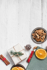 Orange in the cut, cinnamon, walnut on a white background. Branches of Christmas trees, gifts and bumps. A flat place, a place to copy, a top view. Holidays.
