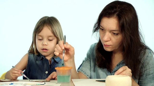 Mom teaches the child the art of painting. A woman and a child of European appearance.