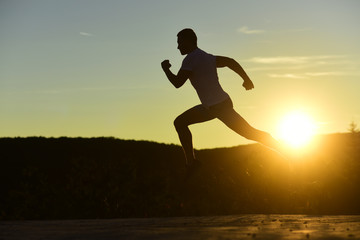Fototapeta na wymiar Sportsman jogging in evening catching the sun