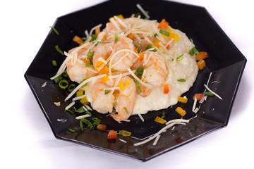 Festive plate of Shrimp and Grits on a black plate