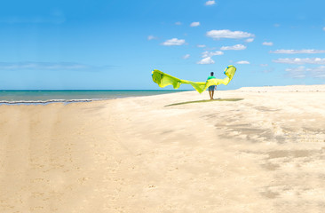 Fototapeta na wymiar Young sportman carrying a kite surf in a beach