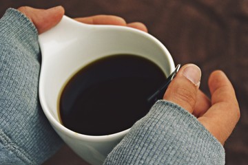 Holding a mug of coffee in the hand