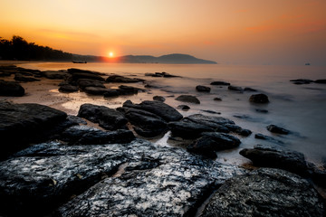Obraz premium Golden sunset with stones on tropical beach of Krabi, Andaman sea, Thailand. Travel, holidays, recreation concept