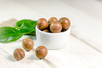 Nice macadamia nuts on white wooden table.