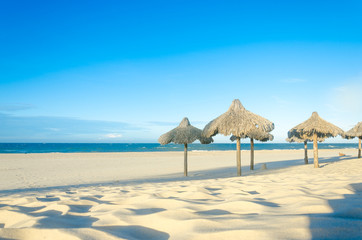 Many sun umbrellas at the beach sand