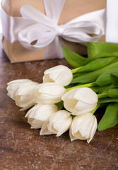 Fototapeta na wymiar White tulips on wooden background