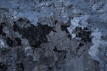 Old dark wall with cracked paint - vintage background