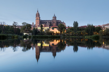 Fototapeta na wymiar Sunset view of Salamanca Old and New Cathedrals from Enrique Esteban Bridge over Tormes River, Community of Castile and León, Spain.