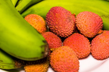 Fresh organic lychee fruit and green bananas. © Sergey Fedoskin