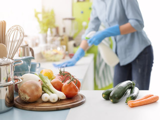 Woman cleaning with a spray detergent