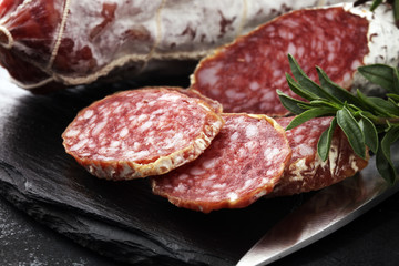 Marble cutting board with sliced salami on it