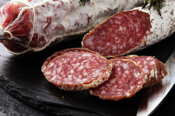 Marble cutting board with sliced salami on it