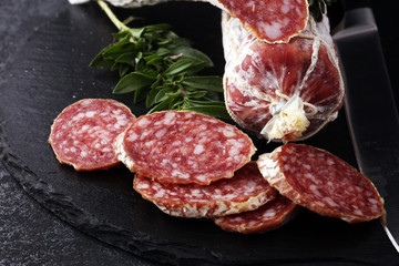 Marble cutting board with sliced salami on it