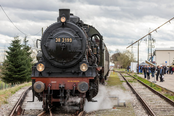 Fototapeta na wymiar Historische Eisenbahn wird am Bahnhof bestaunt