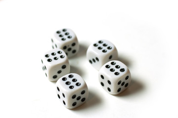 Five white dice on which there are six on the top, isolated