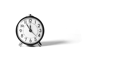 old watch, alarm clock on a white background showing the hour for five minutes twelfth