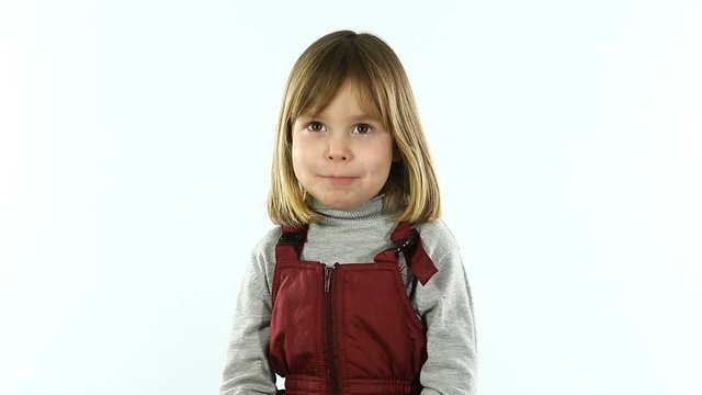 Studio, white background. A little girl of four or five, with blond hair, is photographed for a visa. A child of European appearance.