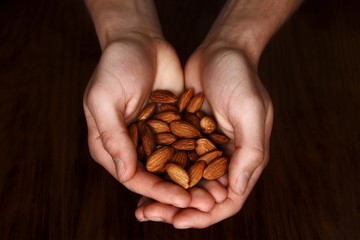 Close-up of handful of almonds - obrazy, fototapety, plakaty