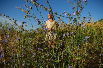 young girl in the field, in the foreground wildflowers. Relaxation and freedom