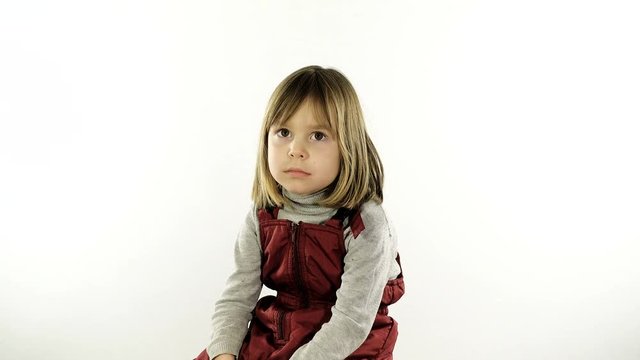A small, very restless girl 4 - 5 years old, with blond hair, is photographed on her passport. She is posing for the photographer. The child is going on a trip with his parents. The flash is working.