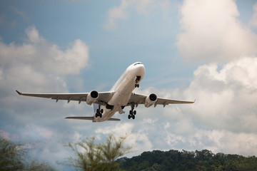 takeoff of a wide-body aircraft from the airport / takeoff moment / partly cloudy on background