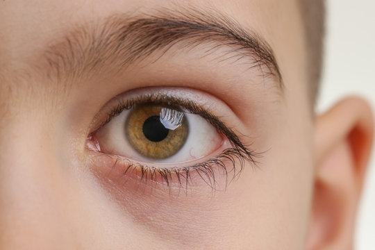 Close up view of a green boy's eye looking at camera