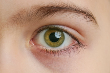 Close up view of a green boy's eye looking at camera