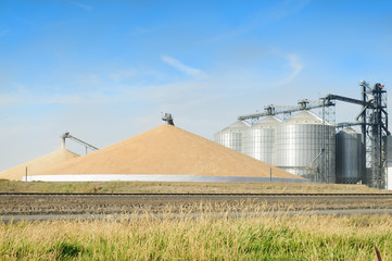 Grain silo's elevator and a mountain of grain in the Palouse, Washington