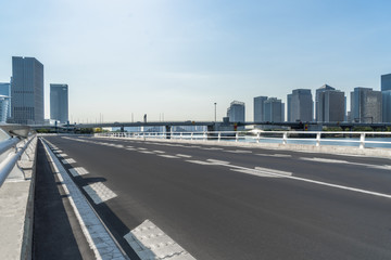 empty asphalt road on modern bridge with city skyline background.