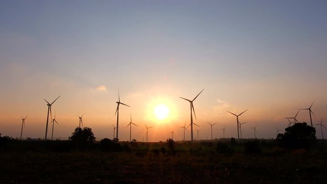 Video of wind turbine farm with sunset for electricity generation. It is the alternative energy. The capacity depends on the velocity of wind.