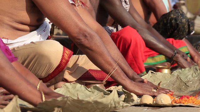 People pray and make a religious ritual on the ghats of the Ganges river in Varanasi, India . Close up
