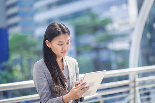businesswoman look at his tablet in outdoor of office.