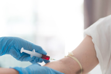 Close up Hand of nurse, doctor or technician in blue gloves taking blood sample from a patient in the hospital.