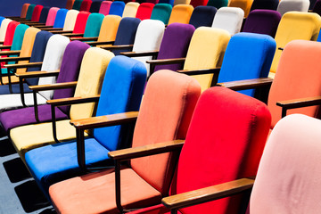 The auditorium in the theater. Multicolored spectator chairs.