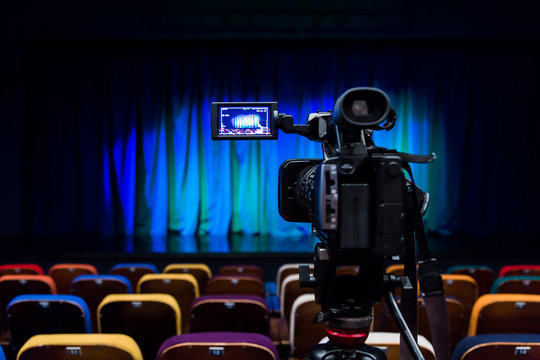 The LCD display on the camcorder. Shooting theatrical performances. The TV camera. Colorful chairs in the auditorium.