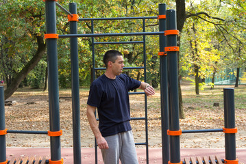 Obraz premium Sport in nature. An athlete looks at his watch. He checks the results achieved