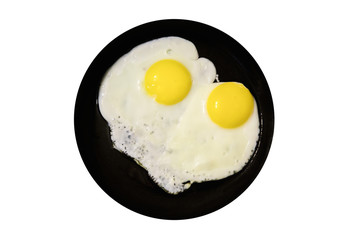 Two fried eggs on a dark saucer on a white isolated background