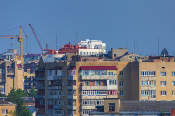 City landscape. Old multi-storey houses and modern buildings against the blue sky. Roofs of apartment buildings.