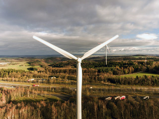 Panorama aerial helicopter view over wind farm landscape in Germany with white generator turbines