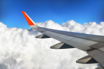 Fototapeta premium View of airplane wing with cloud and blue sky