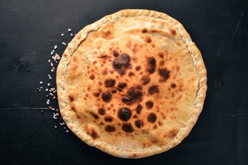 Pizza Volcano. Gorgonzola cheese, cherry tomatoes, fresh vegetables, and spices. On a wooden background. Free space for your text. Top view.