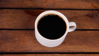 Coffee in white cup on wooden board