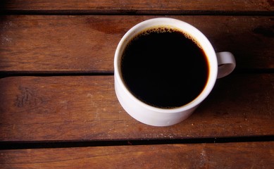 Coffee in white cup on wooden board