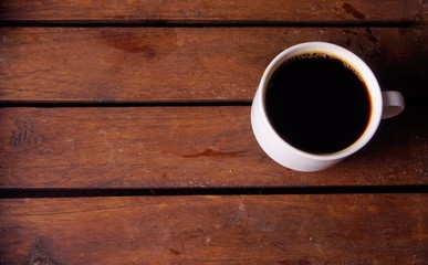 Coffee in white cup on wooden board