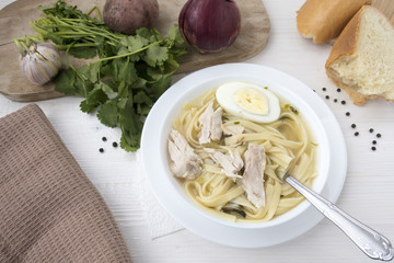 Appetizing chicken soup with noodles, with the addition of potatoes, carrot greens and bay leaf.