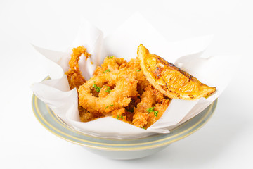 Fried crispy squid rings ( caramari ) Sprinkle sesame seeds top view in a paper on white backgruond
