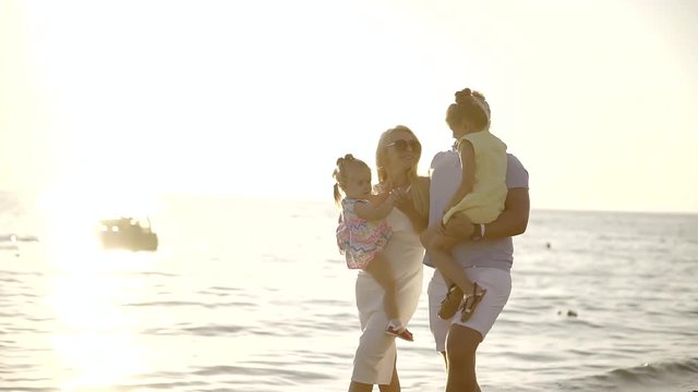 successful wealthy family resting at the vacation at the seaside with young children. a walk at sunset with the kids on hand